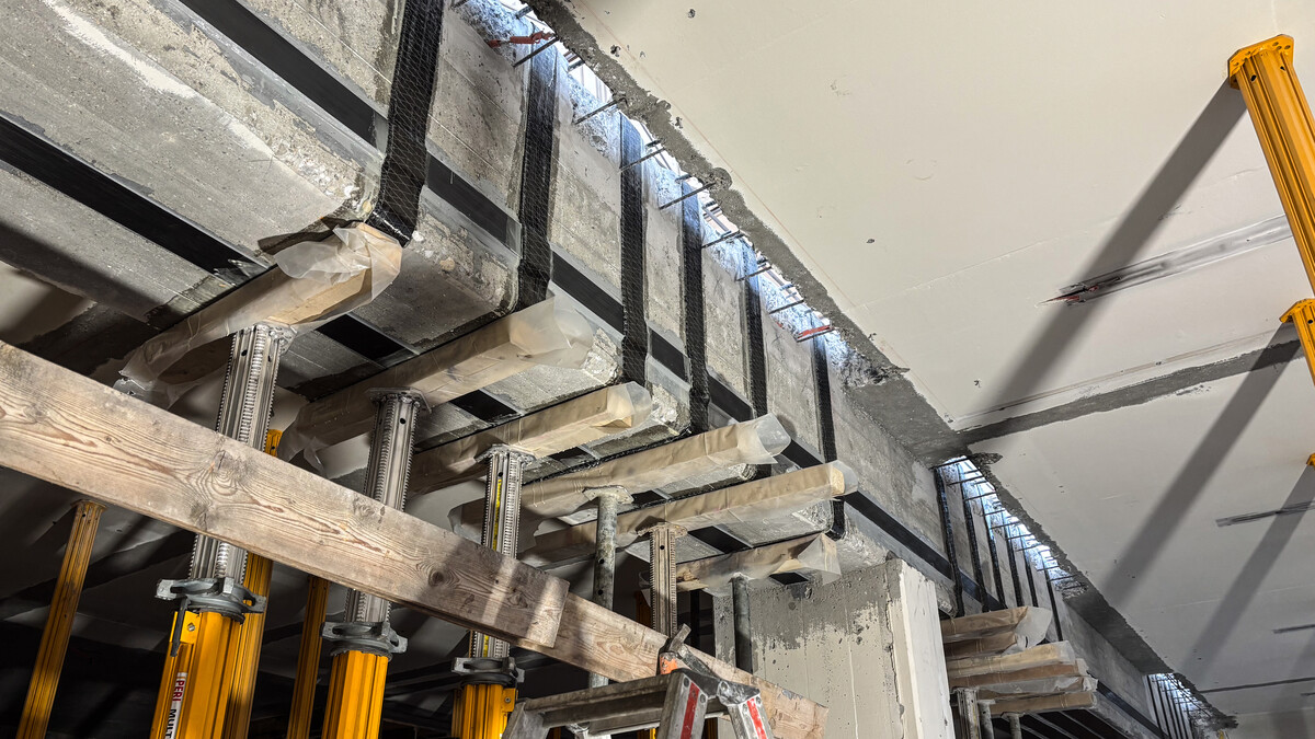 Die Ansicht von Unten auf den Hauptträger mit Klebebewehrungen bestehend aus CFK-Lamellen und gefalteten Carbon-Gelegen.