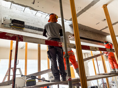 Anbringen der vorgespannten Lamelle an der Seitenfläche des Betonträgers.