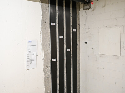 Im Kellergeschoss kommen alle vertikalen CFK-Lamellen der Erdbebenverstärkung zusammen, Spezialteile aus Stahl verankern diese im Beton.